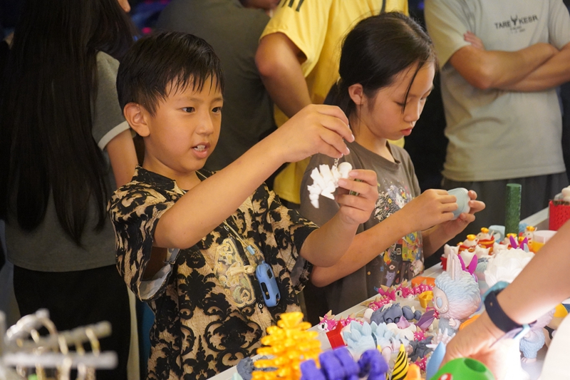 攤位前挑選商品的小朋友。黃源匯攝