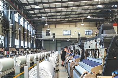 畢節宏盛紡織科技有限公司廠房內，200余臺噴水織機正高速運轉。廖婉君攝