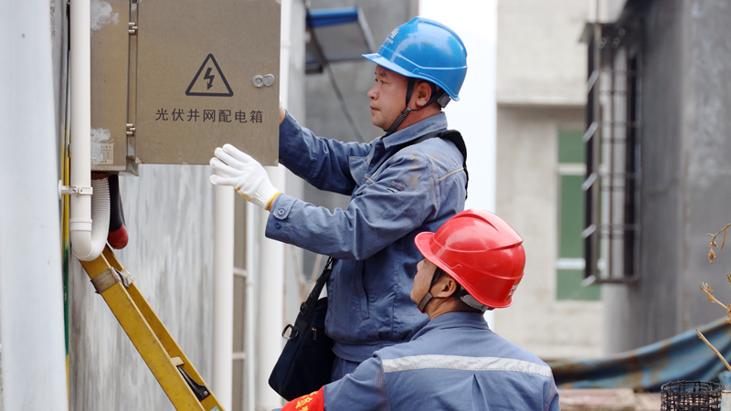 南方電網貴州興義晴隆供電局工作人員上門對屋頂光伏并網設備進行巡檢服務。