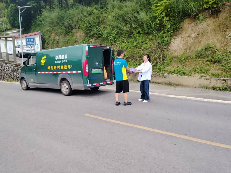 村干部將群眾寄送物品轉交給郵政投遞員.jpg