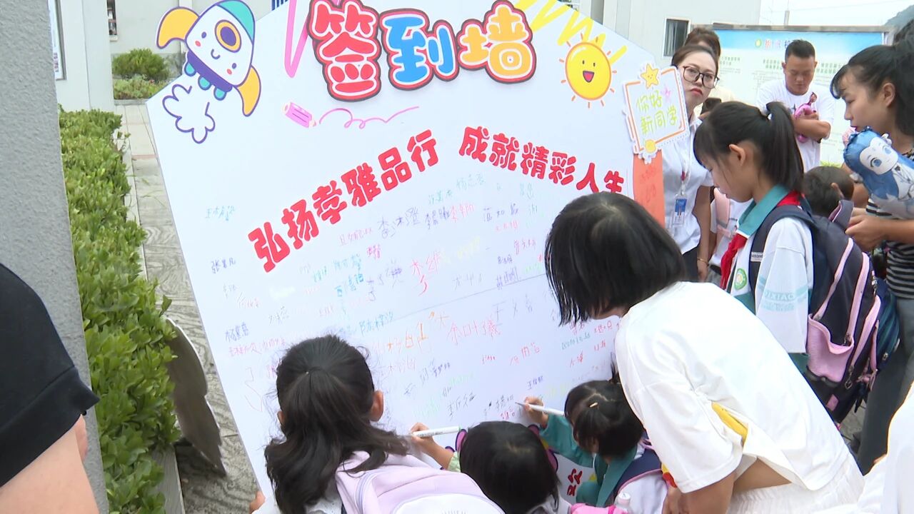 縣第七小學學生在簽到墻上寫下自己的名字。