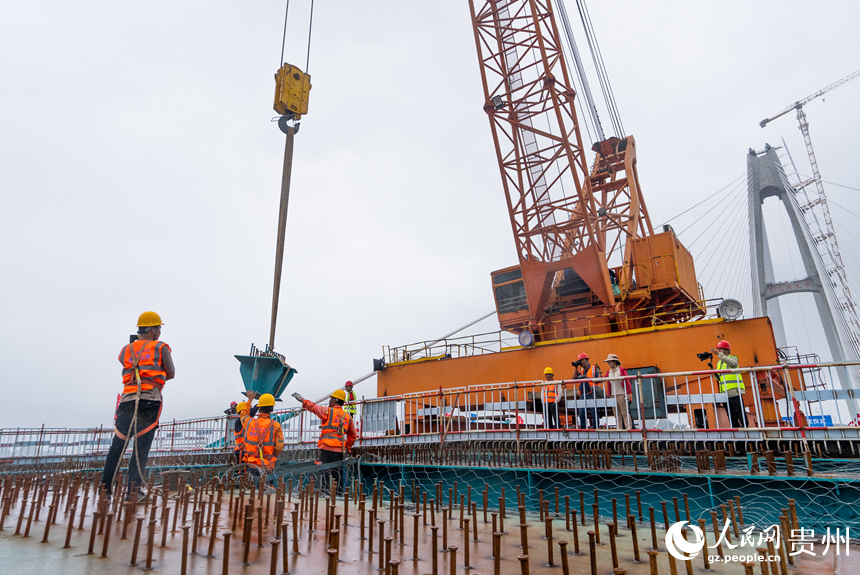 建設者正在吊裝大橋的最后一片小縱梁。人民網記者 涂敏攝