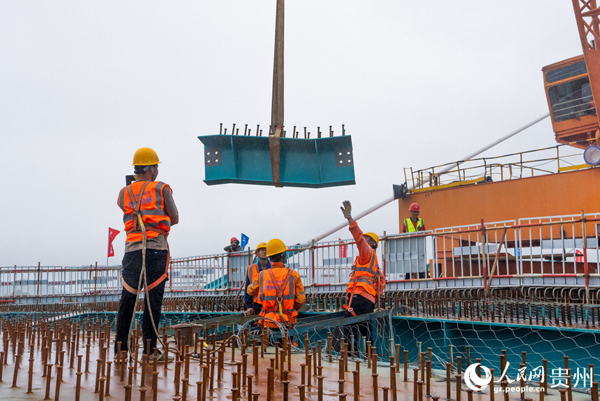 建設者正在吊裝大橋的最后一片小縱梁。人民網記者 涂敏攝