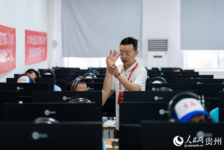 工作人員協助視障考生完成綜合筆試。人民網記者 涂敏攝