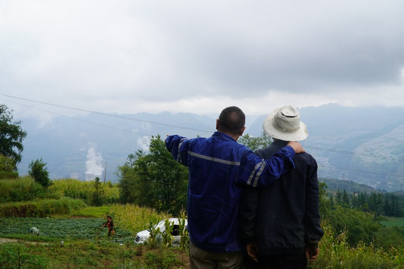 陳彥秋（左）給村民介紹納雍電廠。