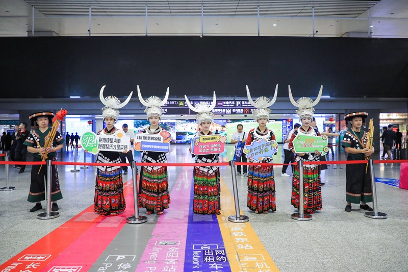 身著精美苗族服飾的姑娘們手舉歡迎牌2