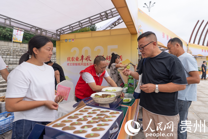 參會嘉賓品嘗修文獼猴桃。人民網記者 涂敏攝