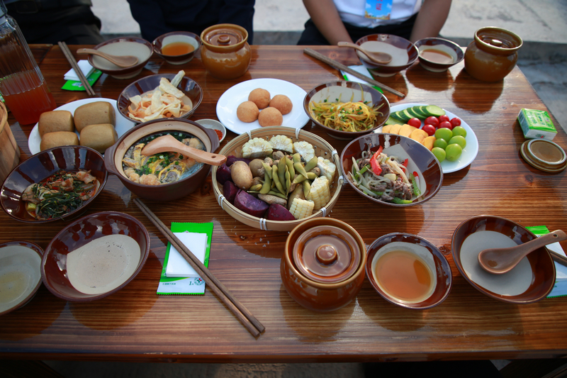 七星關區2025年中國農民豐收節分會場活動現場， 稻田長桌宴 游客與村民共品菜肴，共話豐收年景。