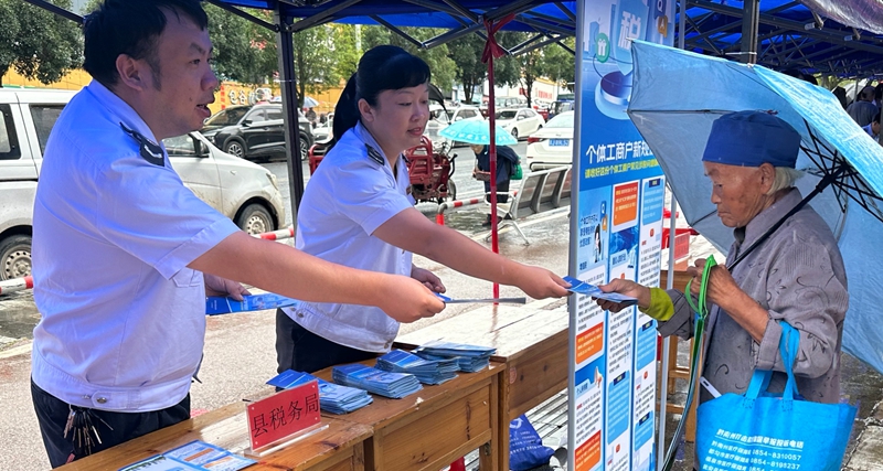 荔波縣稅務局利用“全國個體工商戶服務月活動”為契機向往來群眾發放涉稅政策宣傳資料 (2).jpg