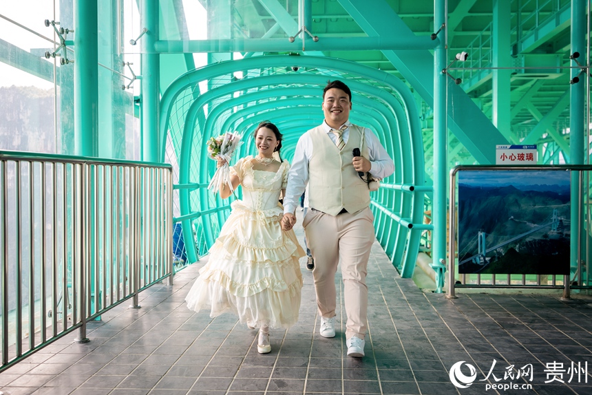 新人在花江峽谷大橋上拍攝紀念照。人民網記者 涂敏攝