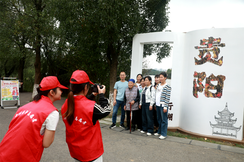 觀山湖區青年志愿者免費為游客趙友文及其家人拍照。