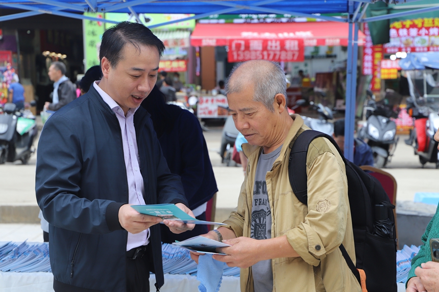 貴州省文化和旅游廳工作人員正向游客詳細講解《旅游安全實務手冊》中的應急避險知識。