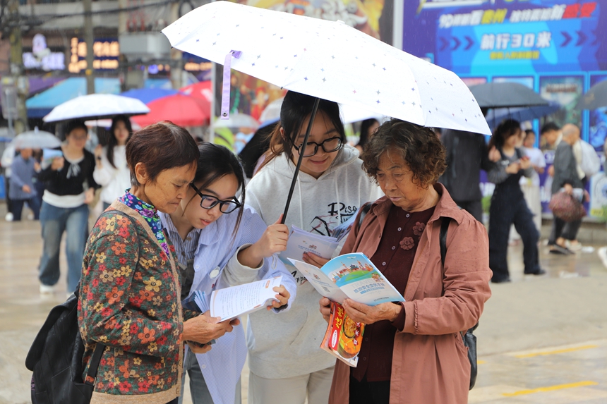 科普現場，學生志愿者正結合《旅游避“坑”指南》，為游客詳細解析常見旅游消費陷阱。