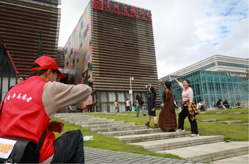 9、在貴州省博物館，觀山湖區青年志愿者為游客們拍照。張婷 攝.jpg