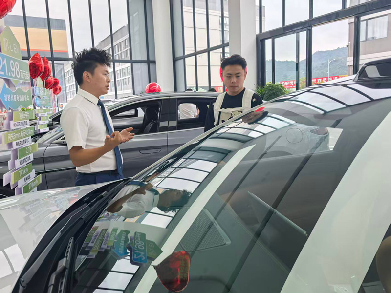 銷售顧問正在給顧客介紹車子的性能。