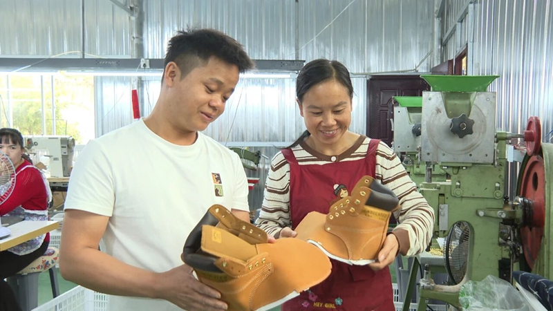 3 圖為楊江海（左）查看工人制作好的鞋面.jpg