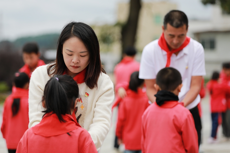 2025年10月13日，貴州省黔西市林泉鎮林泉小學教師在為一年級的少先隊員佩戴紅領巾。 (1)