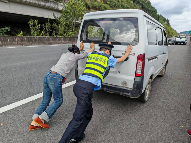 10月4日在G7521渝筑高速K308+600下行，一支隊七大隊四中隊執法人員遇故障車，幫助把車移到右側應急車道。班霞攝