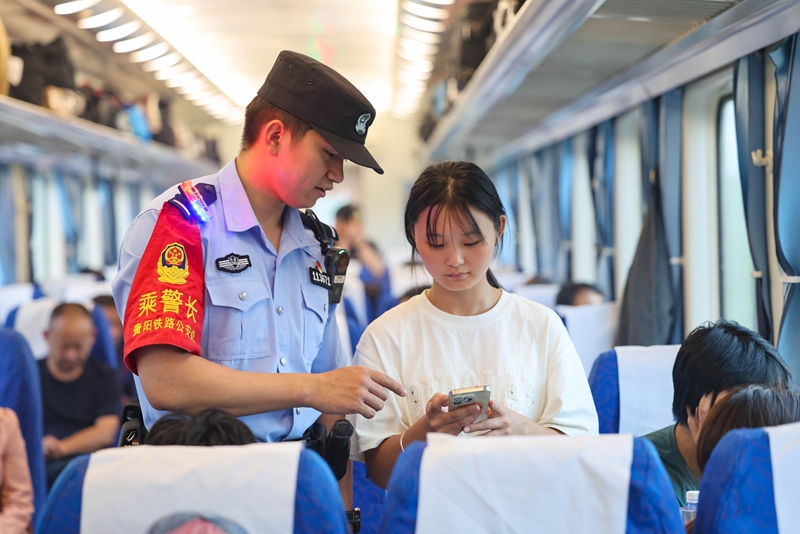 2025年10月14日，劉濤在K845次寧波至貴陽的列車上向旅客宣傳防范電信詐騙知識。