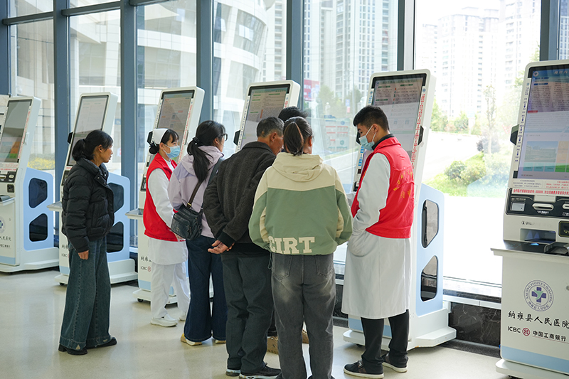 導診護士指導群眾操作自助掛號機掛號就診。胡璐攝