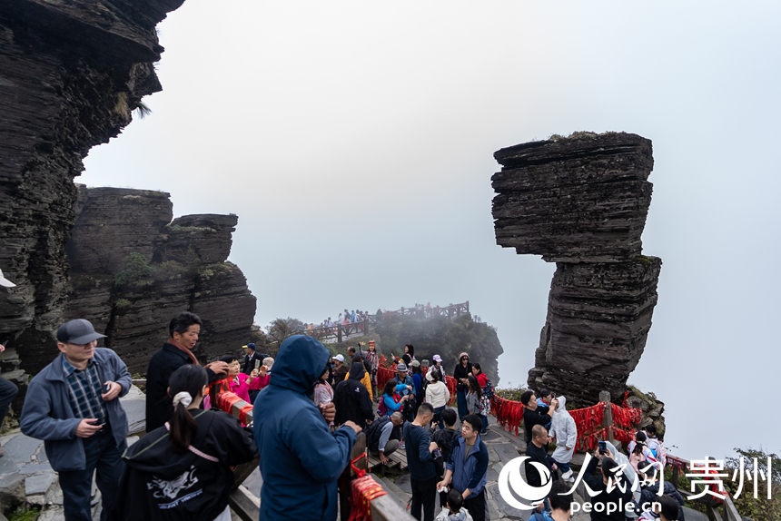 游客在梵凈山景區標志性景點“蘑菇石”處打卡拍照。人民網記者 涂敏攝