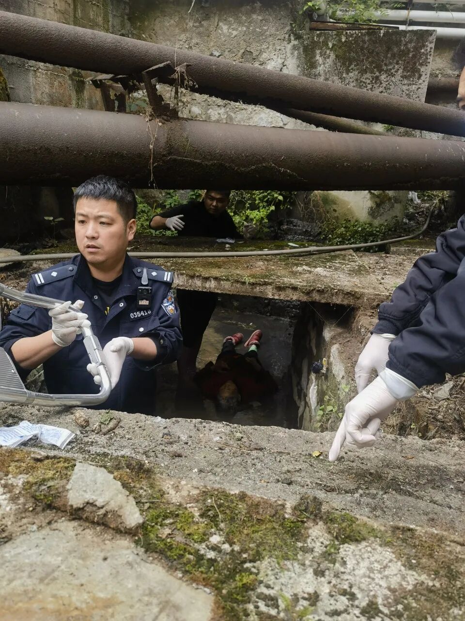 圖為民警在下水溝發現老人。