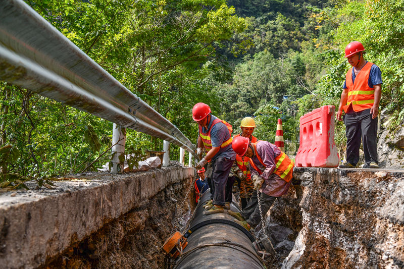 工人在羅甸縣龍坪鎮大關村段安裝管網。潘希來攝 