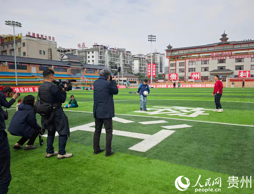 媒體團走進貴州榕江“村超”球場，與“村超”球員交談、踢球。人民網 龍章榆攝