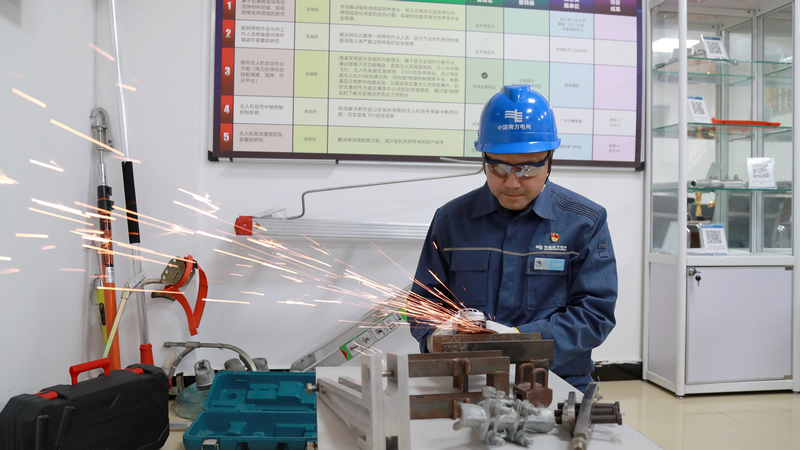 nEO_IMG_南方電網貴州興義供電局輸電管理所綜合數據班高級作業員龍福剛研發安全工具器，確保同事們安安全全地工作，更好地護航電網安全穩定運行。盧關文攝
