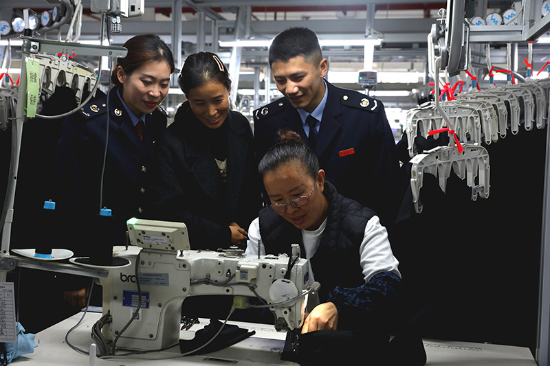 國家稅務總局黔西市稅務局關注當地出口退稅企業發展，為相關企業提供“一企一策”個性化稅費服務，輔導企業依法依規適用稅費政策，更好地防范跨境經營稅收風險。圖為稅務人員在貴州質品服飾有限公司了解生產工藝。劉一帆