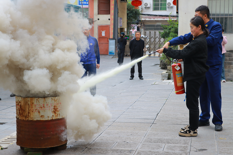 消防員正在教轄區群眾如何使用滅火器。王方攝
