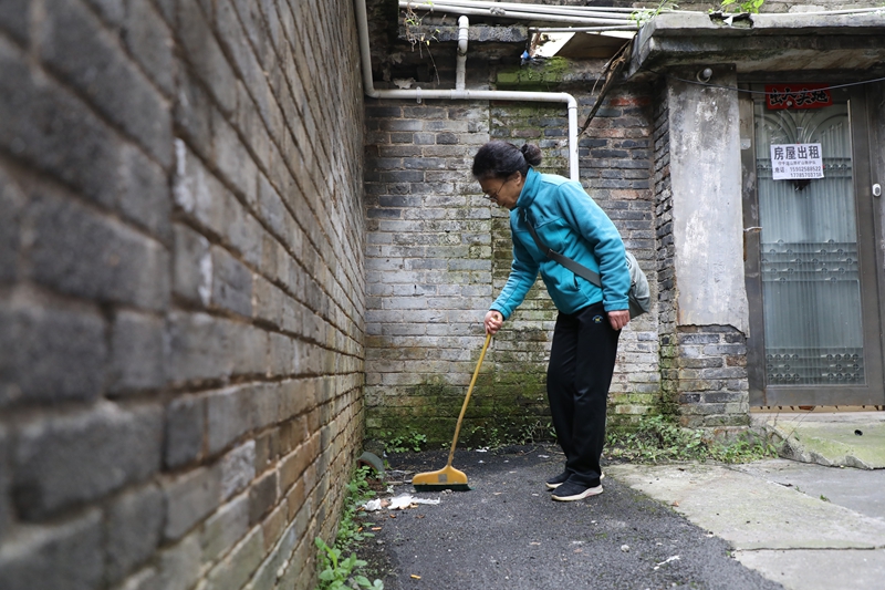 七星關區洪山街道洪山社區老舊小區改造后環境干凈整潔，居民正在打掃衛生。邱夢如攝